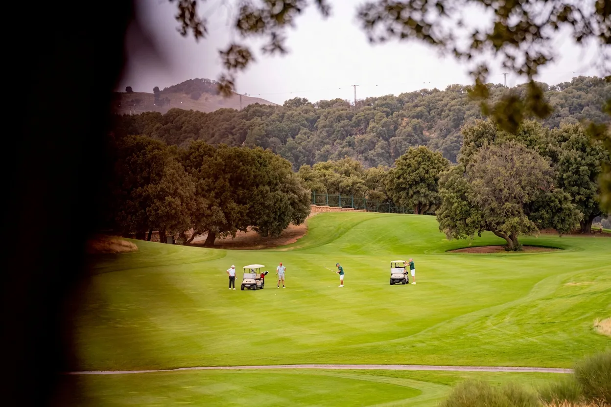 Jugadores en una calle del Michlifen Golf & Country Club rodeada de bosque